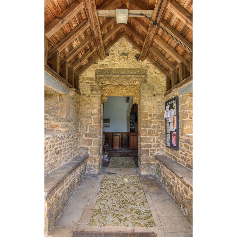 the font is partially visible across the south doorway, to the left -- Source caption: "Interesting carvings above porch door"