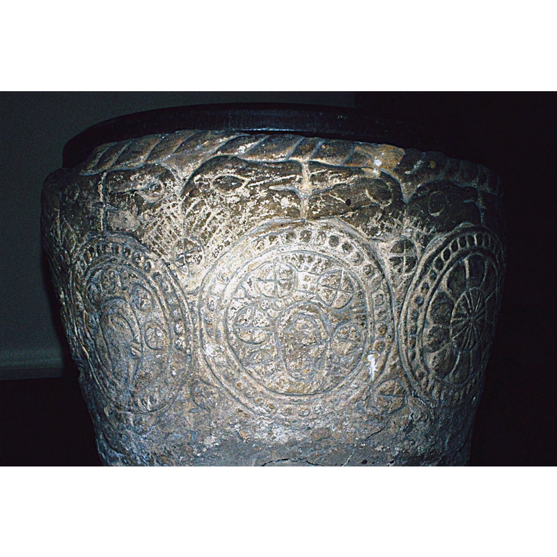 a set of facing beaky heads sandwiched between the upper rope moulded rim, and the circles below
