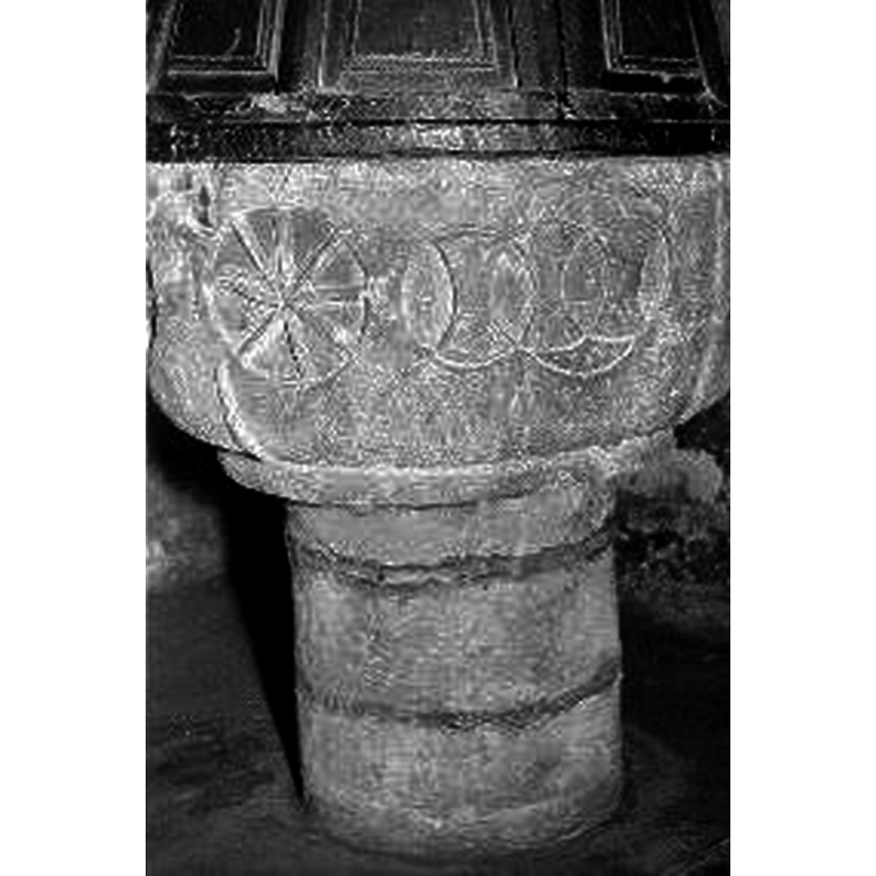unfortunately the source photograph only shows a small portion of the font cover, but enough to gather that it was of the rim-buffet type, made of wood, conical in shape, with panelled sides, some of which probably opened at the front to give access to the interior basin