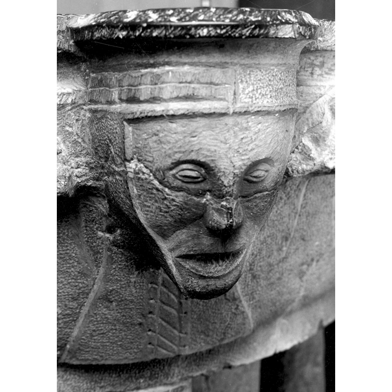 rendered like an old woman with an open tooth-less mouth -- notice the detail in the front of her head-dress, with different left and right patterns