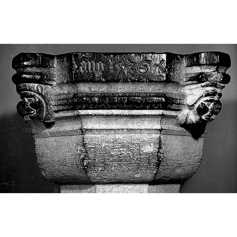 view of the basin showing two of the four heads and part of the inscription