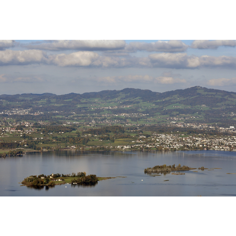 Source caption: "View from the Etzel mountain in Switzerland, focus on Ufenau and Lützelau islands – Kempraten respectively Rapperswil to the right : Zürichsee in the foreground, (from the left:) Feldbach on lakeshore, Hombrechtikon, Dürnten, Tann-Rüti, Rüti and Bachtel mountain (to the right) and Zürcher Oberland in the background."
