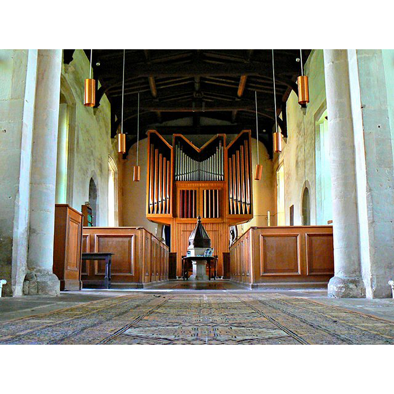 Source caption: "This is a view west from the chancel of the 12th century church. The baroque organ is of recent origin having been gifted to the church in 1968. The light fittings are of about the same age. The half-box pews date to restoration carried out in the 1940s."