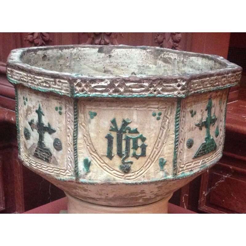 in Gothic lettering, alternating with crosses on the sides of the octagonal font; the shield has fret pattern all around