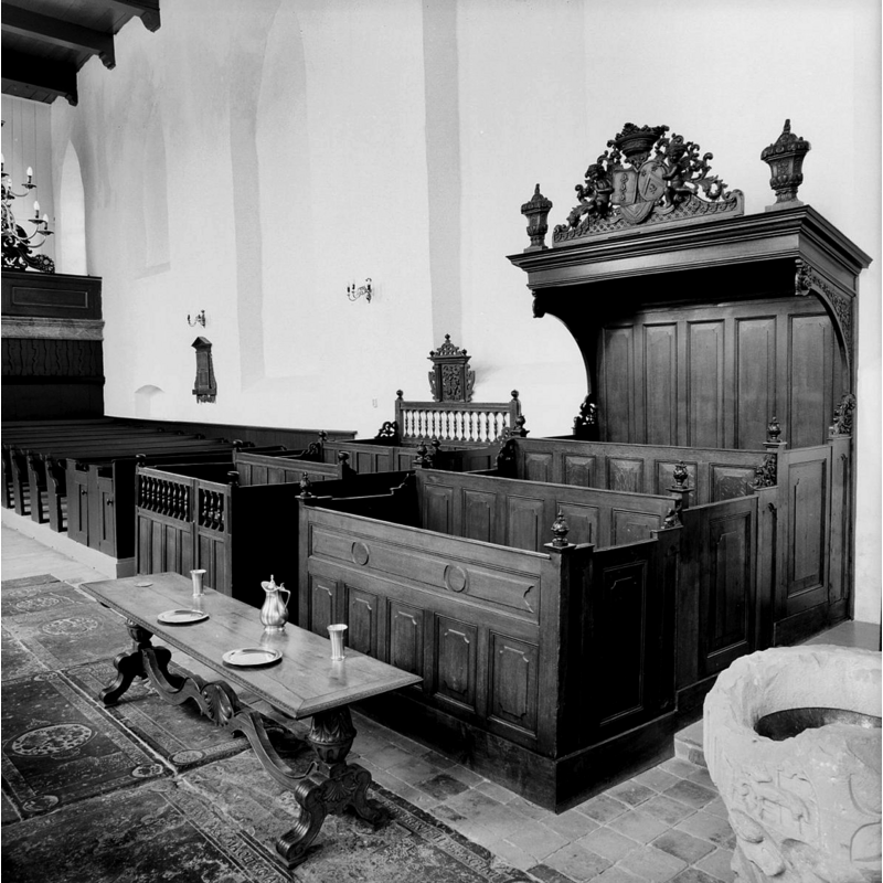 in the lower right corner of the image, next to the male choir-stalls; there is a metal inset inside the basin