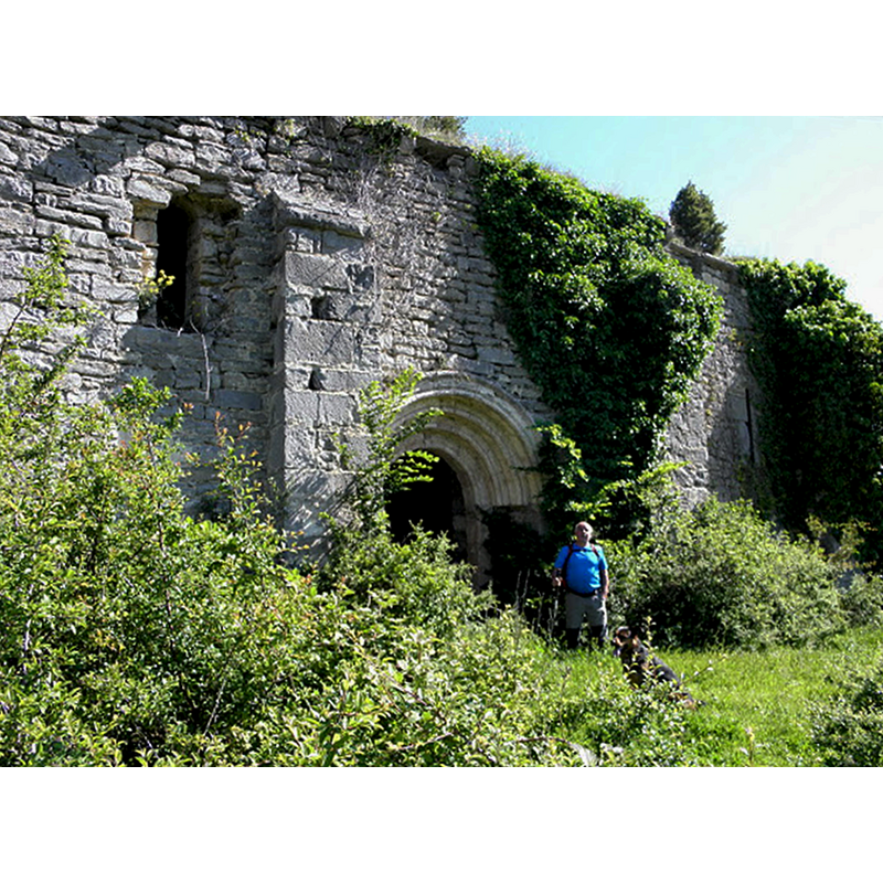 Source caption: "Ex parroquia de S. Juan ante Portam Latinam Templo en ruinas de este mortuorio alavés del siglo XX. Subsiste su portada del siglo XIII con arco de medio punto y parte de los muros y contrafuertes de la fábrica medieval. Parte de la pila bautismal con taza con decoración geométrica se encuentra en el antiguo balneario de Zuazo de Kuartango."