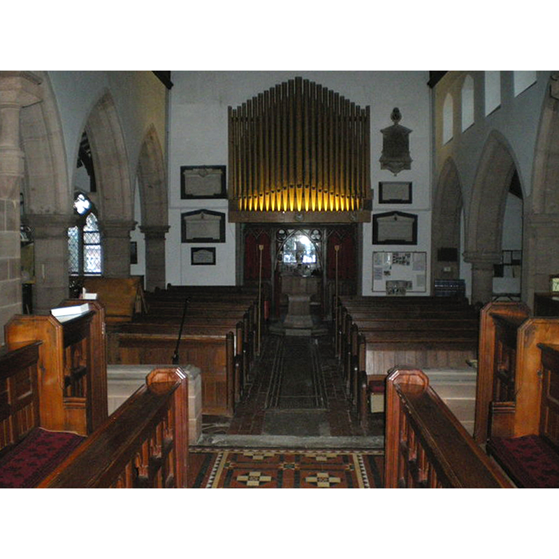 Source caption: "Inside St Milburga's Church. A fine set of organ pipes stands above the font."