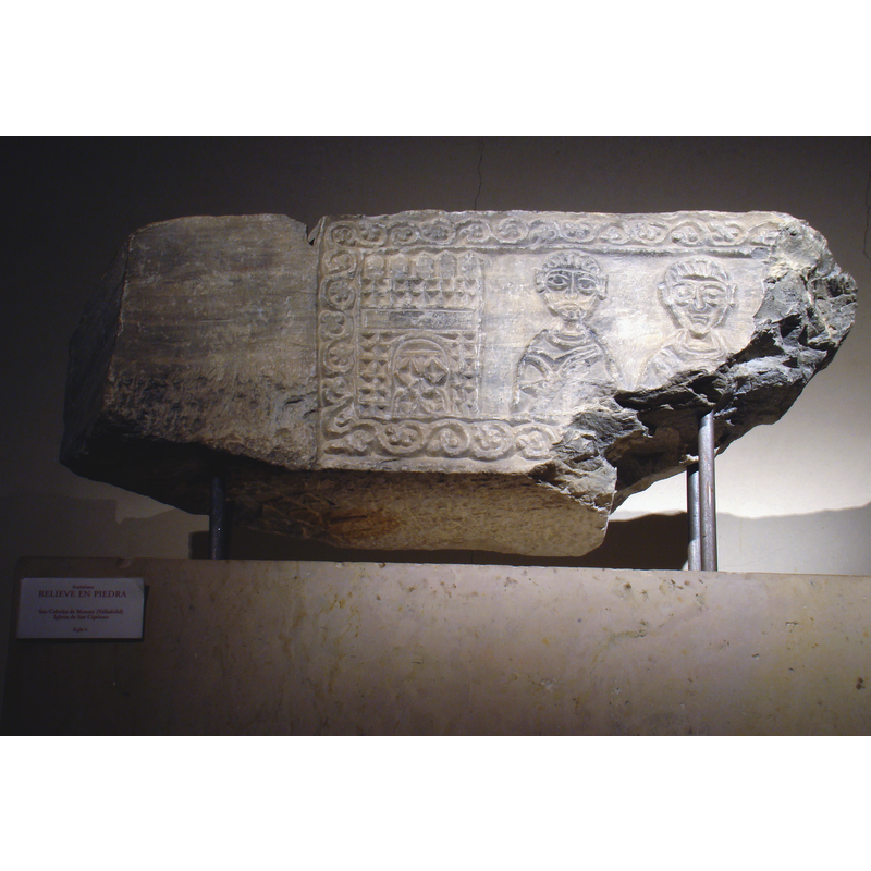 Source caption: "Iglesia mozárabe de San Cebrián en la localidad de San Cebrián de Mazote, Valladolid, España. Bloque de piedra de 62 X 27 cms, rescatado en la restauración de la iglesia, mozárabe, del siglo X. Representa un edificio almenado, con arcos de herradura y dos bustos de personajes bendiciendo. Puede ser parte de un dintel."