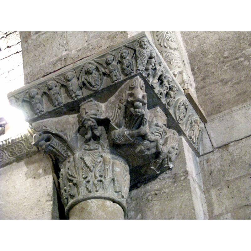 Source caption: "Rechtes Kapitell aus dem Siegesbogen der romanischen Kirche Santa Maria de Porqueres, Katalonien (Szenen mit Engeln und Szenen mit Adam und Eva im Garten Eden) / Right capital in the victory arch of the romanesque church Santa Maria de Porqueres, Catalonia (scenes with Angels and scenes with Adam and Eve at the garden Eden)"