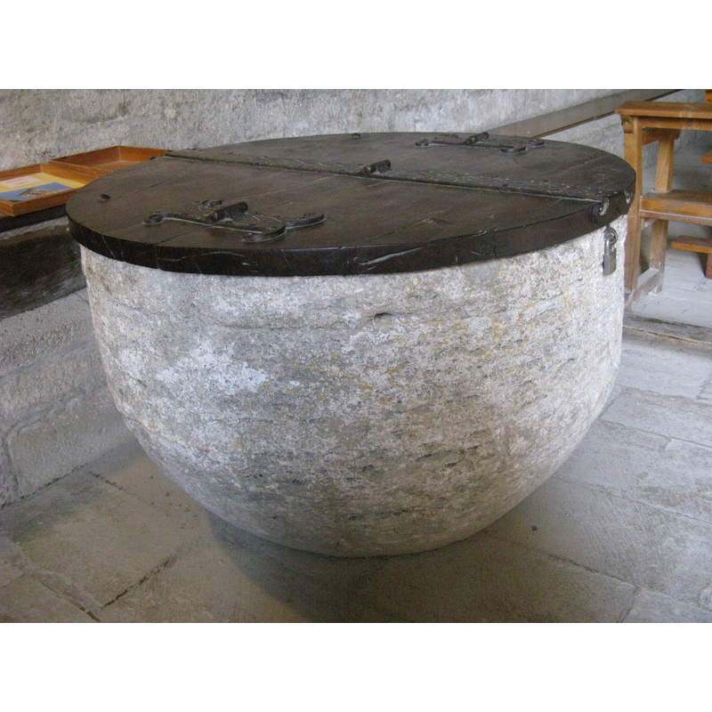 Source caption: "Romanisches Taufbecken aus Travertin; Kirche Santa Maria de Porqueres, Katalonien"