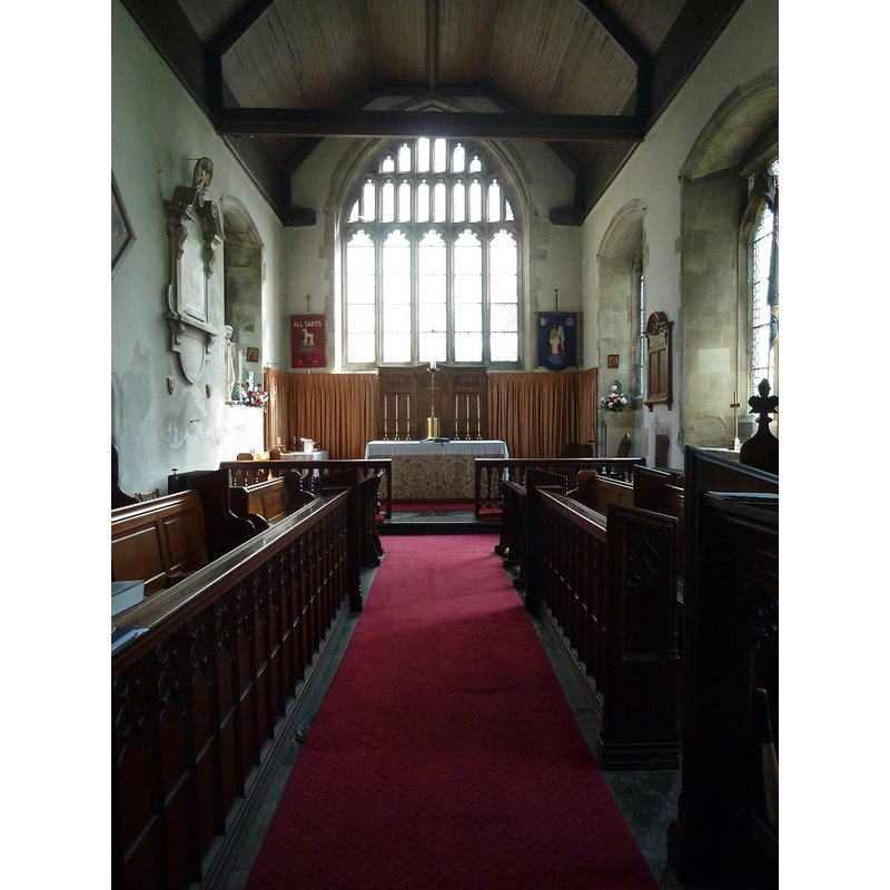 Source caption: "The chancel of All Saints, Houghton Regis leading to the altar, and behind that the plain East Window. In former times this window would have been filled with mediæval stained glass, no doubt removed and destroyed by the iconoclasts of the C17th under Cromwell."