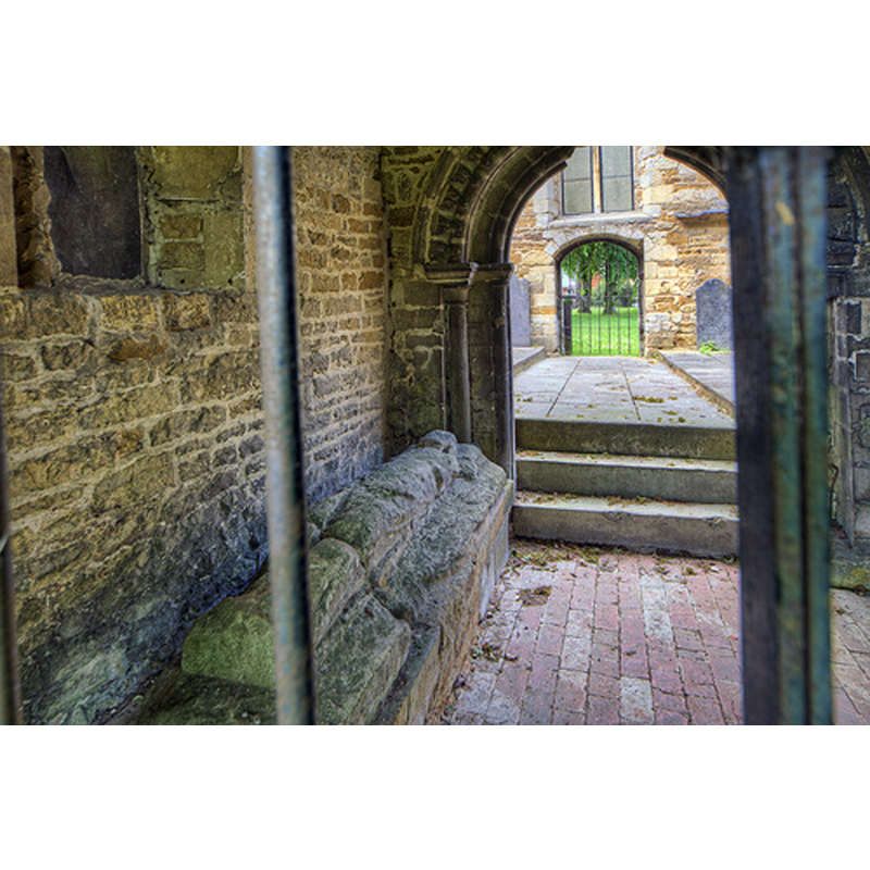 Old St. Mary's chapel -- Source caption: "The 14th century porch, the 12th century doorway and the 15th century tomb."