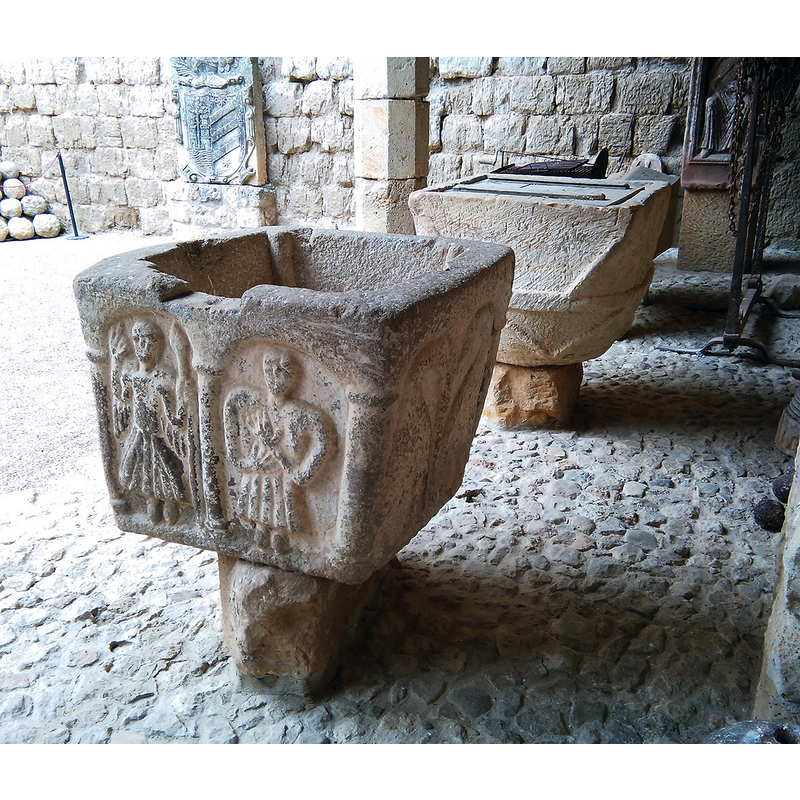 pairs of arches on three of the sides; a single one on the side with the Agnus Dei