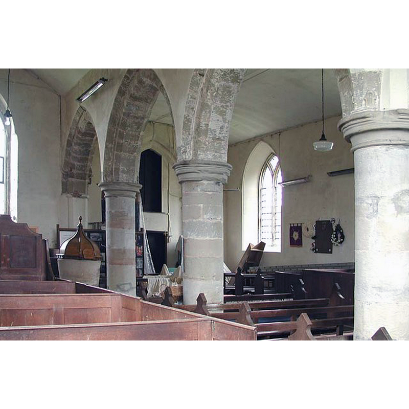 view across the south arcade into the north side; the font and cover are partially visible by the westernmost pillar of the south arcade