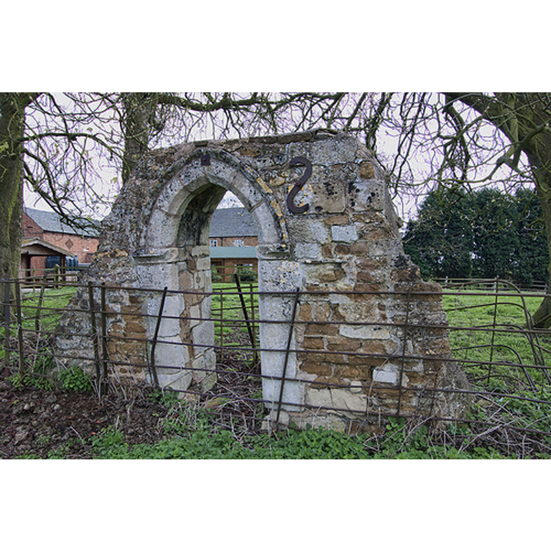 Source caption: "The north door is all that remains of the earlier nearby church."