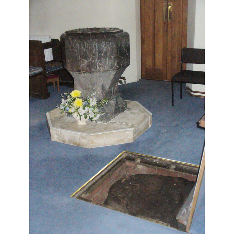 next to the font a trap door on the floor