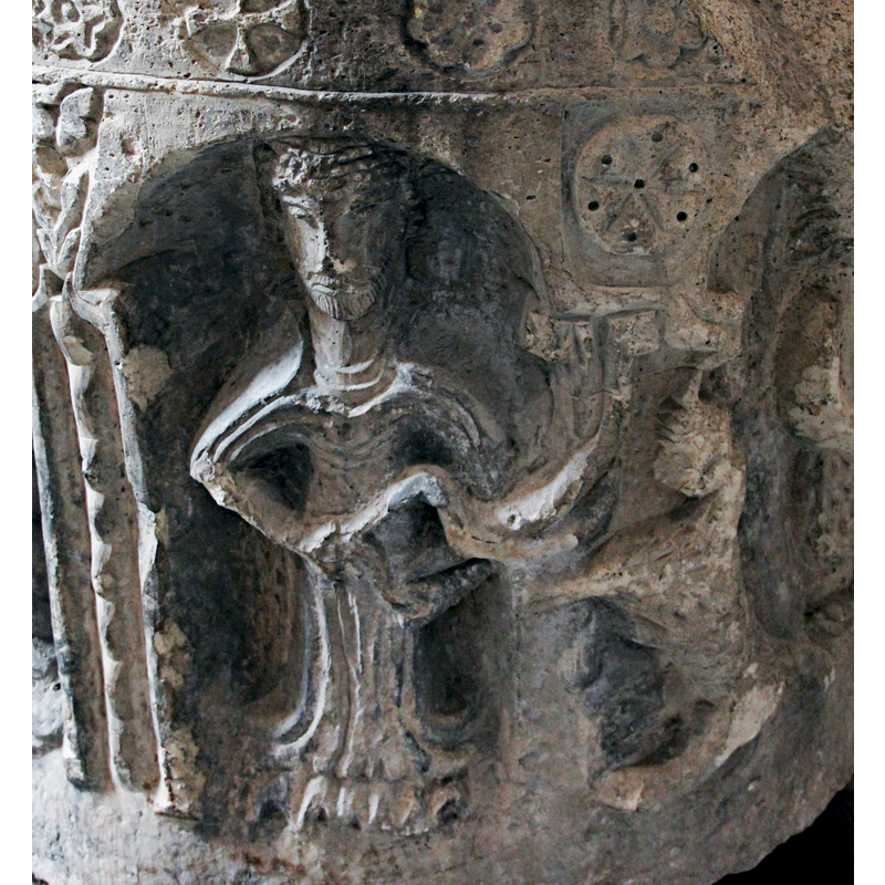 the ressemblance to a rampant lion requires a lot of imagination, of course. What else? a rhinoceros standing on its hind legs waiting to be petted? -- the column that would have supported the arch on the right appears to have been sacrificed in favour of other decorative aims