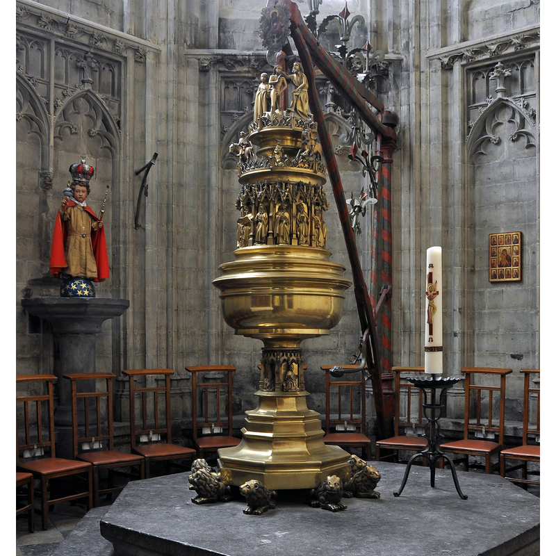 Source caption: "Halle (België): interieur van de Sint-Martinusbasiliek - doopkapel met 15de-eeuwse doopvont / Hal (Belgique) : intérieur de la basilique Saint-Martin - chapelle baptismale avec fonts baptismaux du 15ème siècle" -- harp-shaped crane has metal arm visible here to the right of the stem of the font