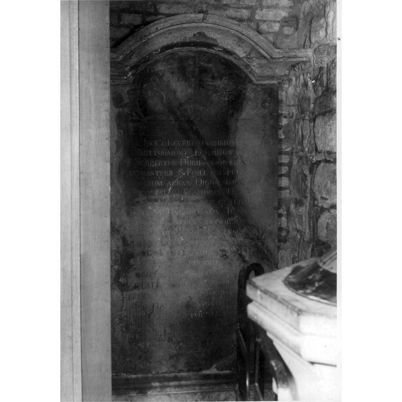 the edge of the font and its cover appear in this 1968 photograph showing its location by abbé Norbert Durieu's 1812 funeral monument