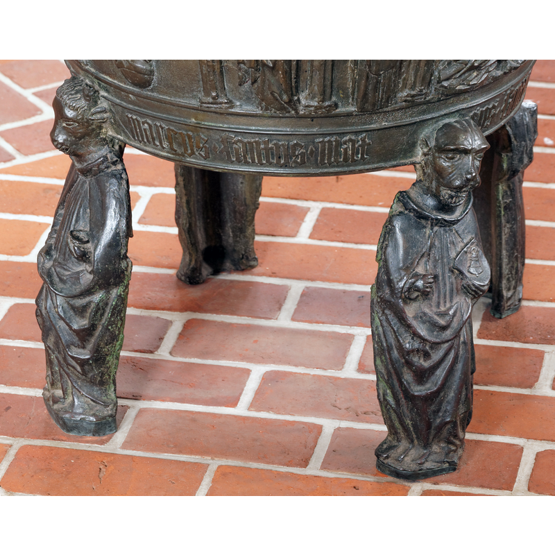 not the usual representation of Mark, the Evangelist; seen here on the right, it consists of a human figure with an lion head, holding a bag or pouch with a bell (?) on it in the left hand -- the inscription on the lower end of the basin, between the heads, identifies Mark