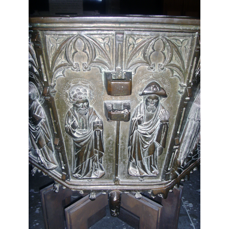 the one Apostle with several symbols of his identity, including a shell in his left hand, the charactreistic pilgrim's hat with a shell on it, and, though nouw missing, it looks like he had an object in his right hand originally, probably a staff -- notice also the two large anchoring protrusions, part of the font cover locking hardware
