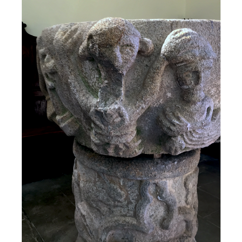 the combination of these two figures, to the right of the trefoiled cross, has been identified in at least one source [cf. FontNotes] as the Baptism of Christ, suposedly John on the left with his left hand on Christ's head; the very fact that it is the left hand raises immediate doubts about such identification; is that a book in his right hand?