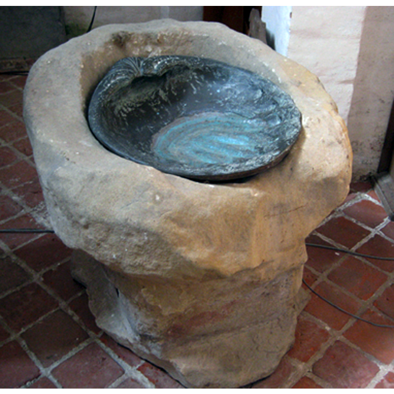 the fragment of the Bentheim sandstone from Heveskes, as displayed in the church of Termunten in 2005 -- the metal baptismal dish was made in 1969 by G. Piek