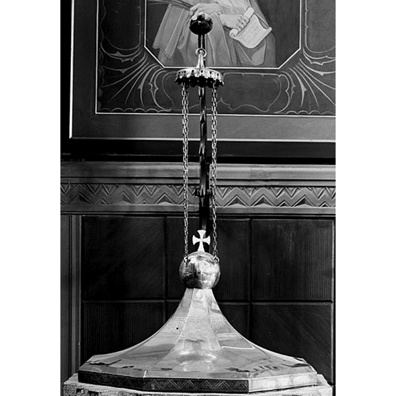 the set of chains attached to the cover finial hang from the end of the arm that stands behind the font and allows for the cover to be raised and swinged to a side
