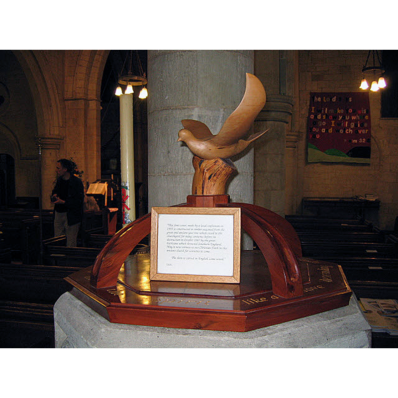 Source caption: "Font cover of St Margaret's church, Chipstead. The notice on the font explains that the cover was carved in 1993 from wood of a yew tree in the churchyard that blew down in the great storm of 1987. The dove is in lime wood.