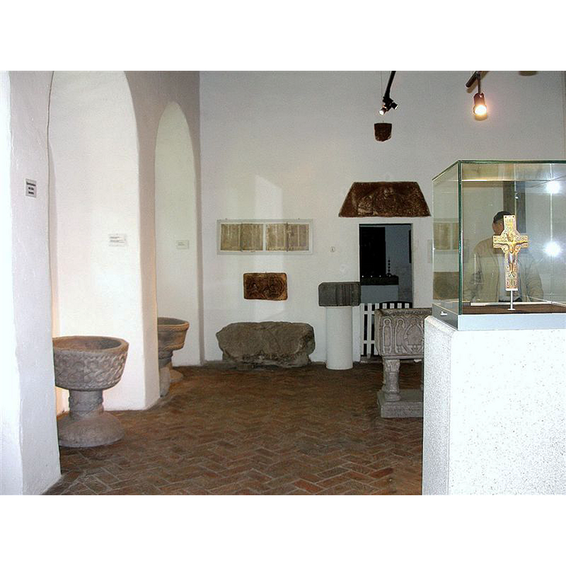 inside the Sarpsborg Borgarsysselmuseum; the replica copy of the Skjeberg font is partially visible behind the white display case
