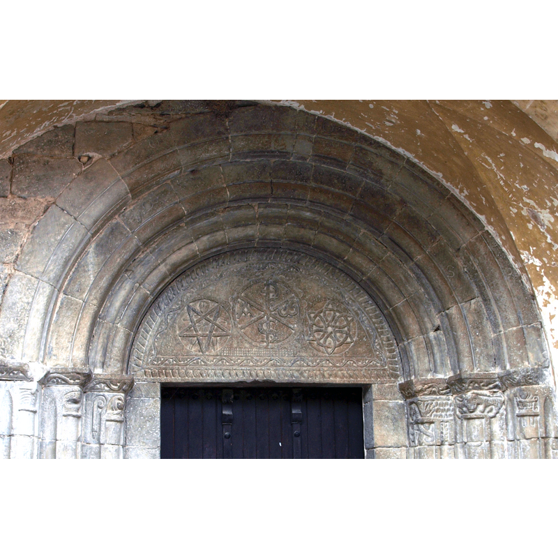 on the left a pentagram with a human figure 'caught' in it; in the centre a chrismon; an interlace on the right; framed in rope moulding and decorated with vines, reticular pattern, etc.
