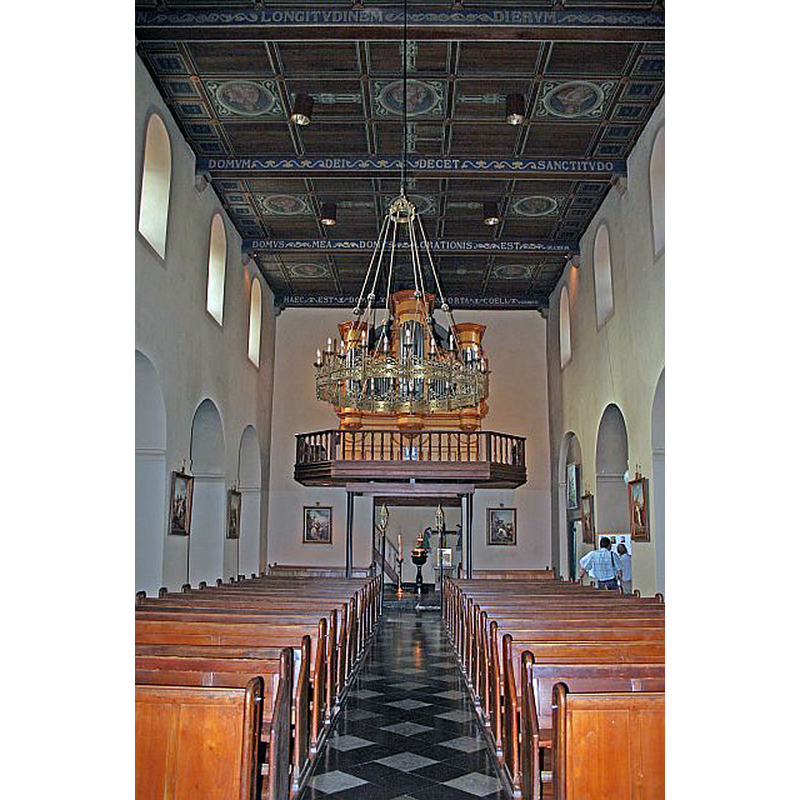the later black marble font is visible at the west end of the nave, beneath the tower