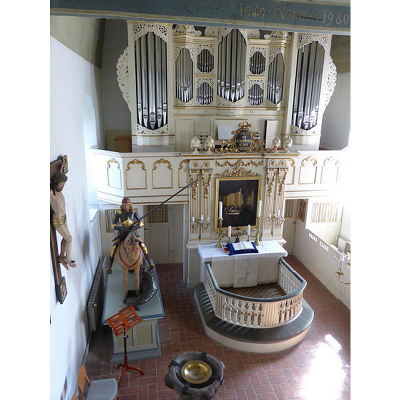 in the foreground, at the east end of the nave [NB: font, gallery, organ, altar and retable are all uncharacteriscally together at this end (as well as ST George and the dragon)]