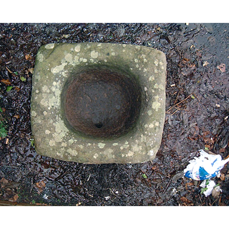 Source caption: "Vertical view of font following removal of flowers. Measuring c. 50cm by c.55cm by c. 40cm high, the font had been shaped by random pecking. The tooling marks had been eroded by wear around the mainly smooth lip. The underside of the font was less even, suggesting that it had originally been mounted on a base. A drain which pierces the base of the bowl has been formed by pecking rather than drilling. The stone is likely to represent a baptismal font, and may well date from the Early Christian period. The parish church in Old Kilpatrick is the most obvious (but not the only) source for the font, it possibly being removed from the church at the Reformation for safe keeping and subsequently lost to history."