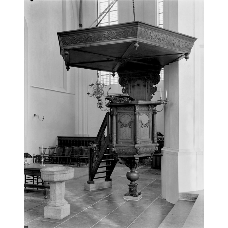 the modern stone font by the pulpit; notice also the ashtray-like Reformation-style metal font mounted on the steps on the hand-rail of the 17th-century pulpit