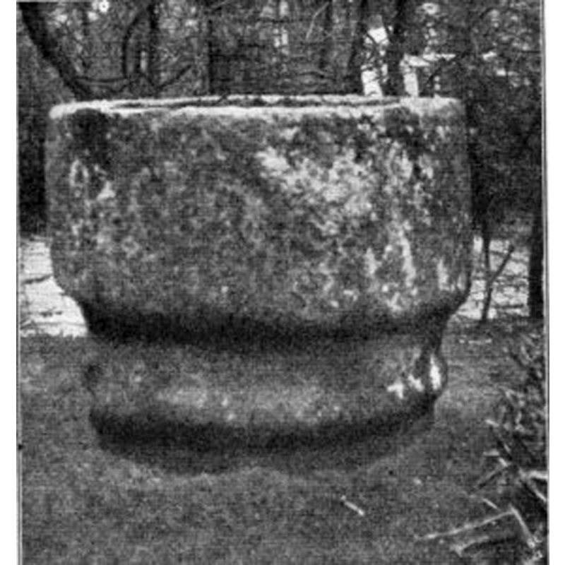 the font while it was still partliy buried in the rectory garden -- Source caption: "Das linke Bild zeigt den halb eingegrabenen Taufstein aus Granit etwa im Jahre 1903 im Garten der Pastorei."