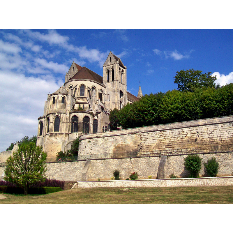 Source caption: "L'abbatiale et l'enceinte du prieuré depuis l'est (parc derrière le château de la Guesdière)."