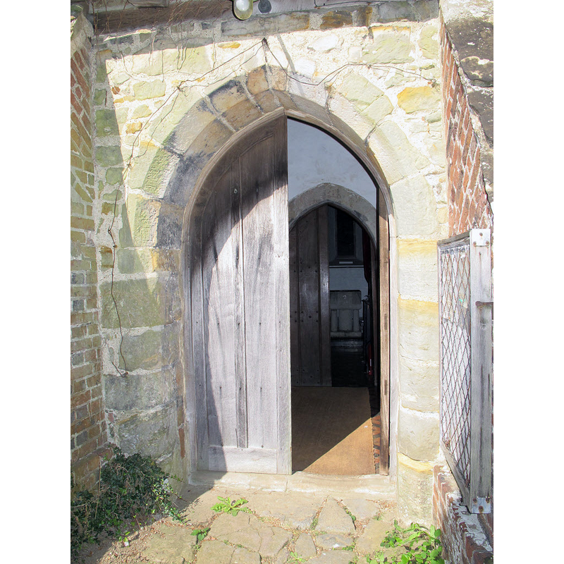 the font is visible inside the church, through the doors of the south porch and portal