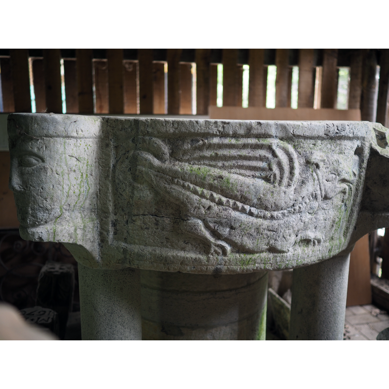 like the one on the font at Huy (Reppe), it has a patterned line all along the body -- located on the side between a lion head with vegetation (left) and the pair of intertwined dragons (right)