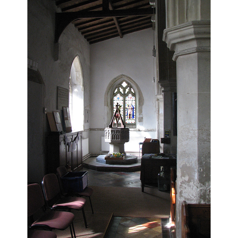Source caption: "Longstanton: All Saints - south aisle and font. The font is "[a]n exceptionally interesting example of the octagonal Perp type. The bowl has on its eight sides eight different fanciful varieties of quite plain motifs of Perp tracery, one with an ogee arch, one with quatrefoils, one with trefoil niches under the arches, two with a band of crenellation half-way up, and so on" (Nikolaus Pevsner)."