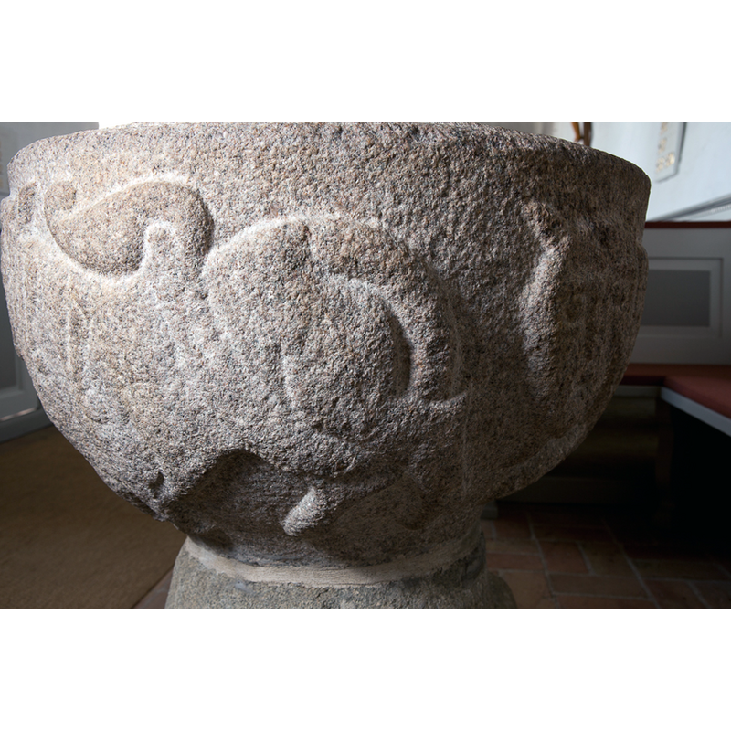 on the left is the rump of one of the two lions that are set to the sides of the human head; notice the artistic tuft of the tail end; on the far right the head of the third lion is discernible