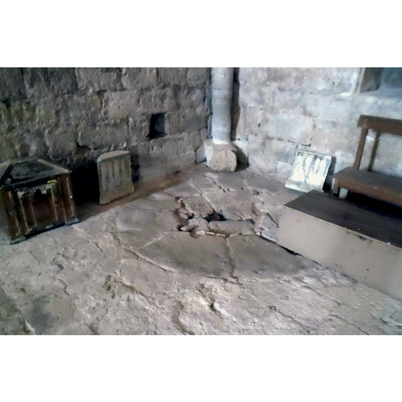 the plinth of the font in its original position; the font was later moved to the centre of the aisle but the plinth and the drain hole remains in situ
