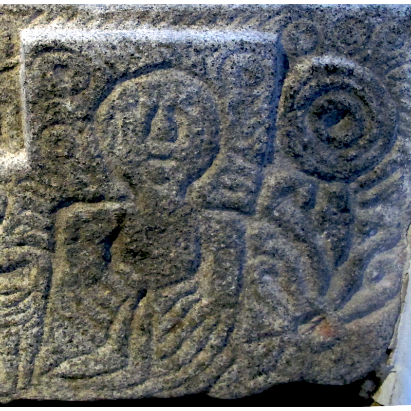 one of three; the figure on the right side of the front panel; appears to have been carved to denote distinction/rank - stylised Majestas Domini with the Tetramorphos around its head?