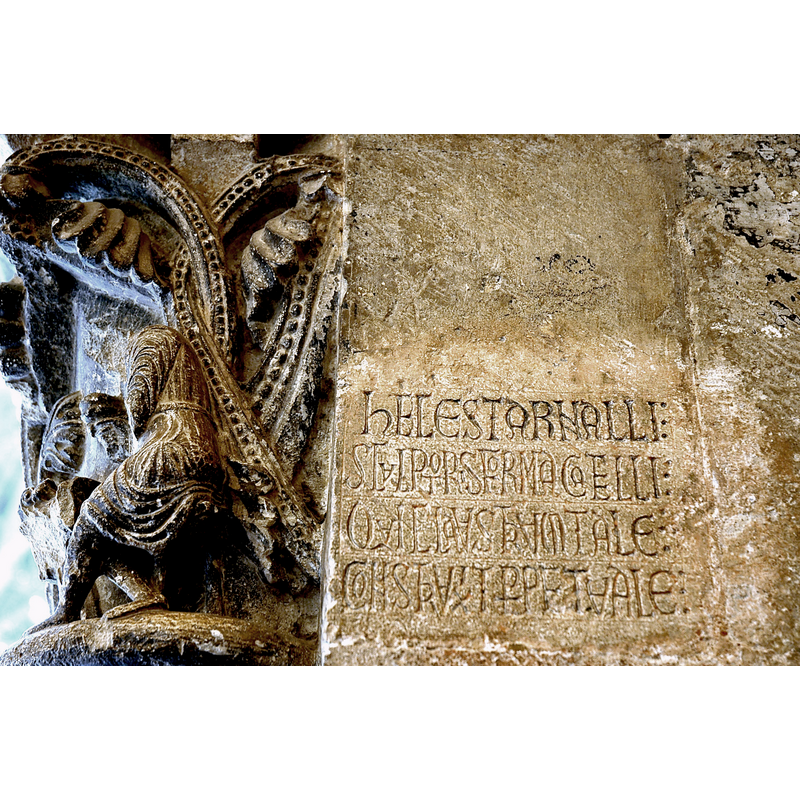 Source caption: "Monestir de Sant Cugat - Inscripció d'Arnau Cadell -- "HEC EST ARNALLI / SCULTORIS FORMA CATELLI / QUI CLAUSTRUM TALE / CONSTRUXIT PERPETUALE"