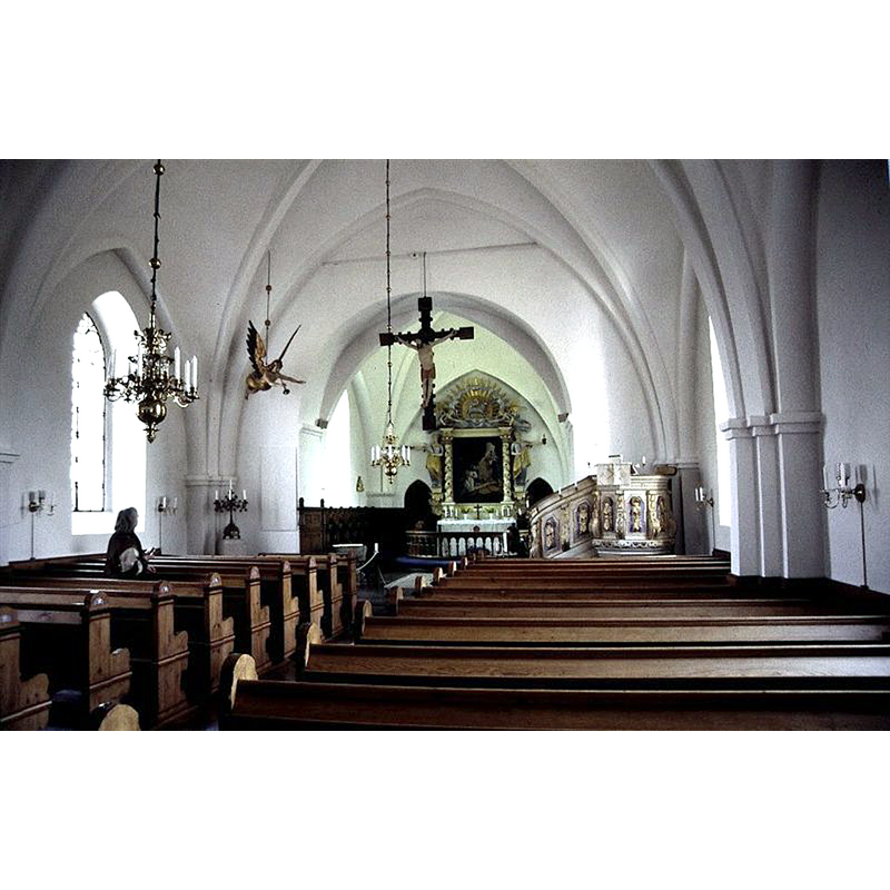 the font is partially visible at the far [east] end of the nave, left [north] side, in front of the choir stalls; obviously not its original location