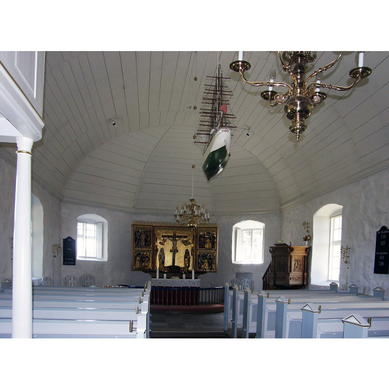 the font is located at the east end, behind the left bank of benches; not visible here though the top of the metal baptismal dish can be discerned
