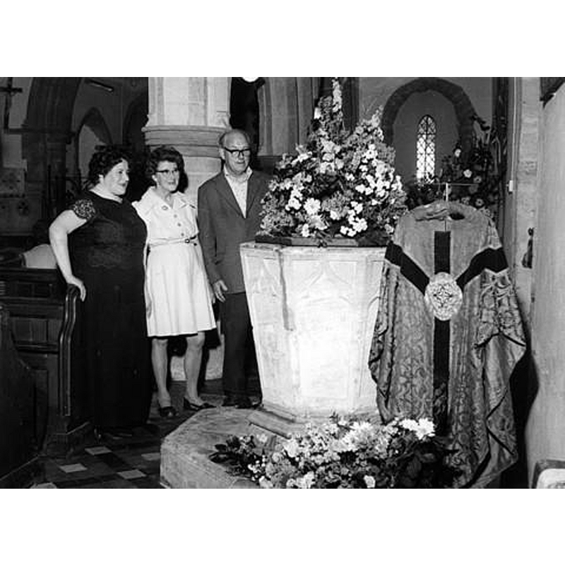 Source caption: "The changing face of Fritwell. Beryl Wrighton, left, and Mr and Mrs Marcus Turner admiring an arrangement on the font"