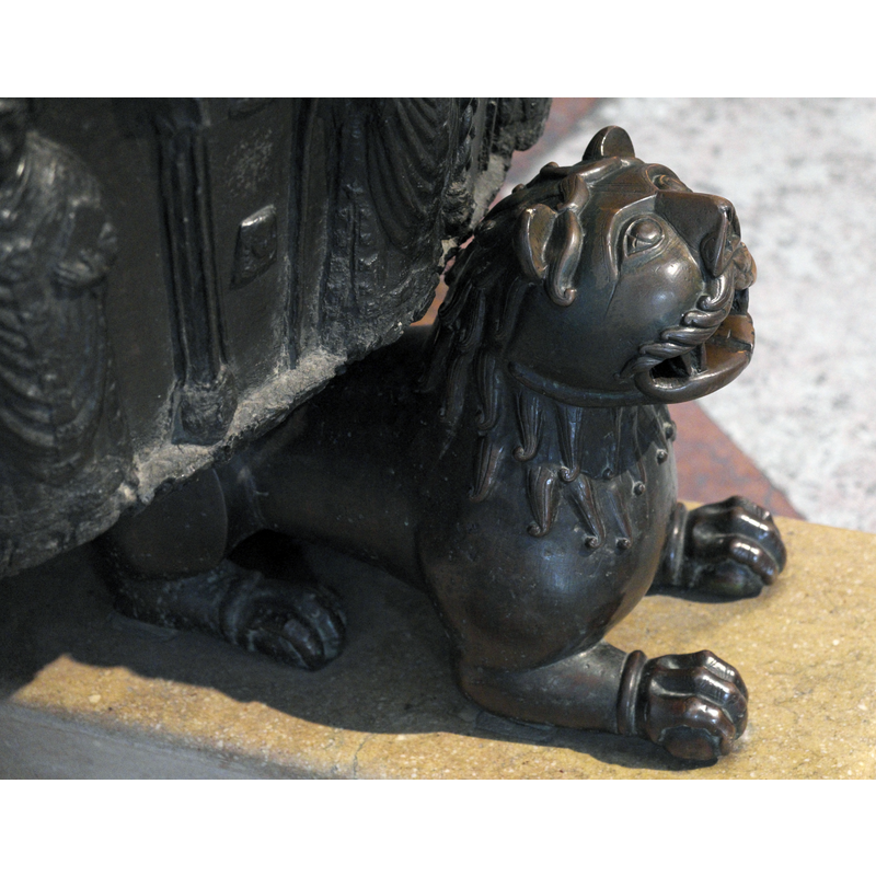 Source caption: "Romanischer Bronzelöwe am Taufbecken des Doms in Salzburg (Österreich), um 1180."