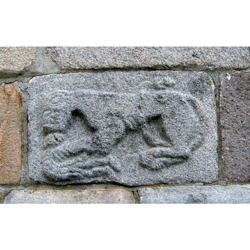 Source caption: "Løve angriper menneske på apsis, Rygge kirke (granitt relieff)"