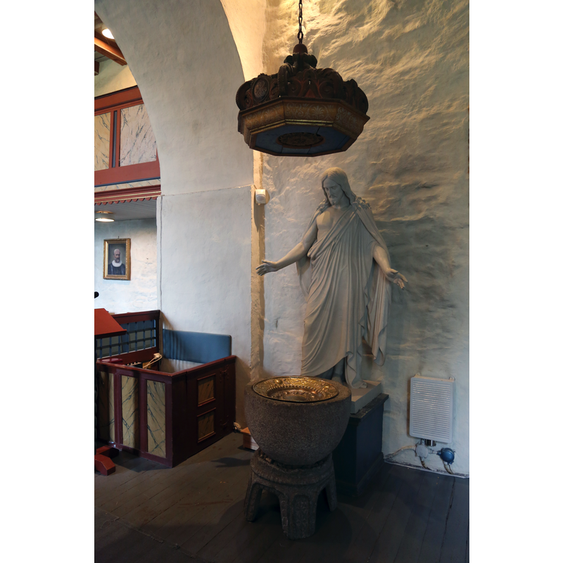 the font is a composite of two unrelated parts; the statue is a copy of Bertel Thorvaldsens' 1871 Christ in Vor Frue kirke, Copenhagen; the canopy looks like a sounding-board